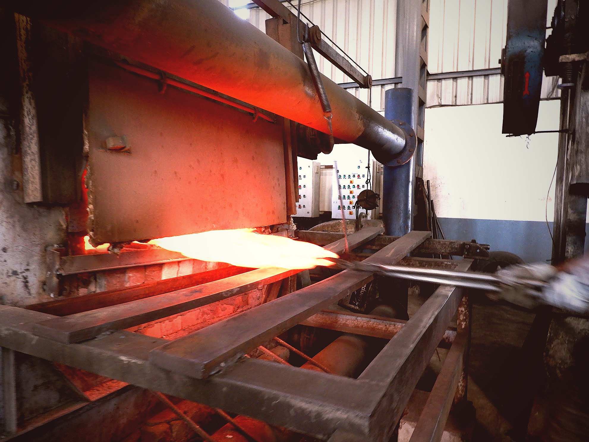 Disc blade glowing red-hot exiting furnace conveyor