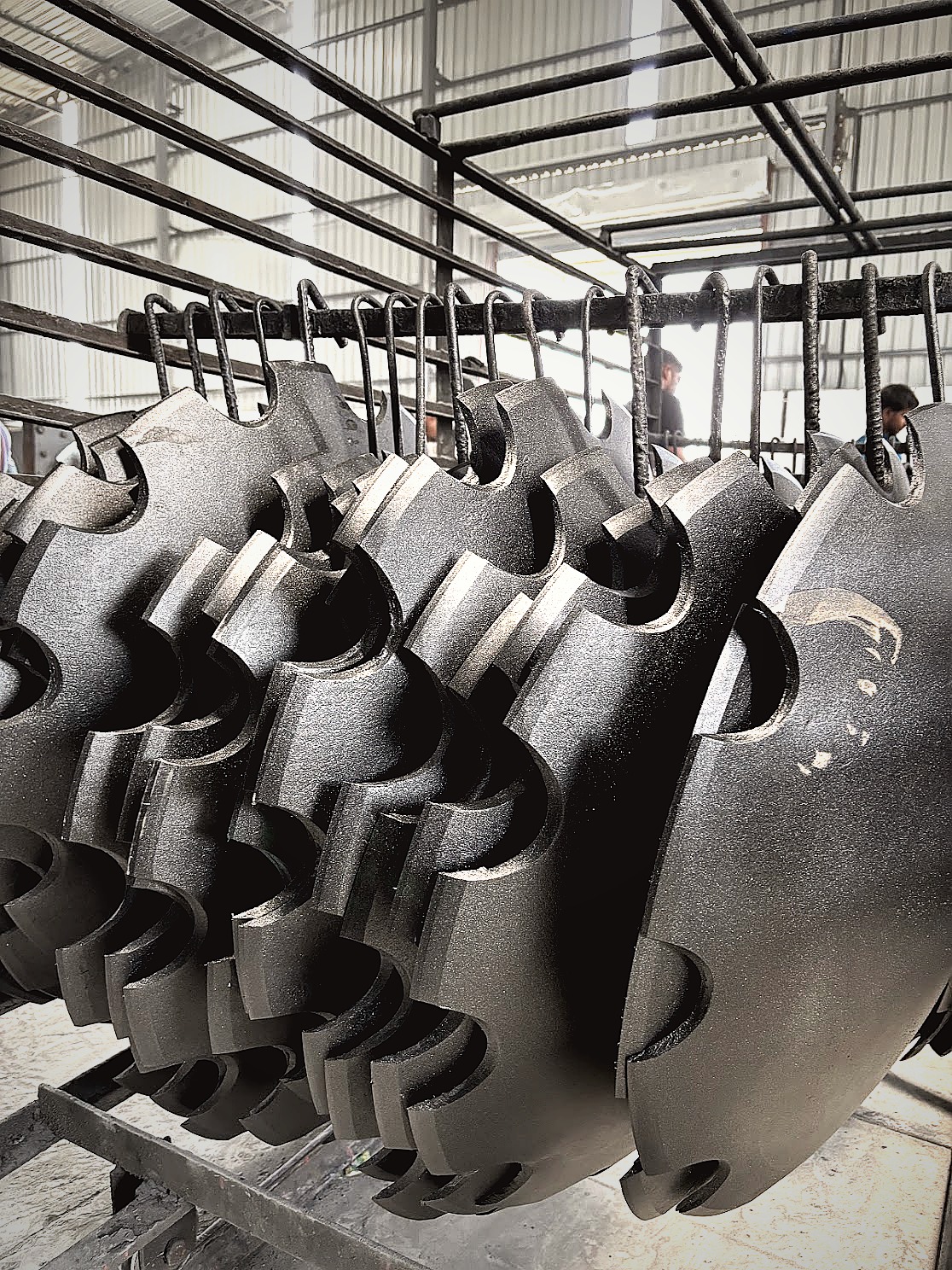 Notched disc blades hanging on rack post shot blast